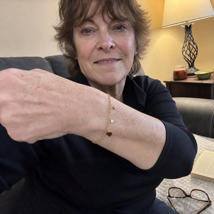 Carol showing her gold charm bracelet